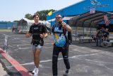 Tandem skydiver and his instructor smile and walk toward the airplane.